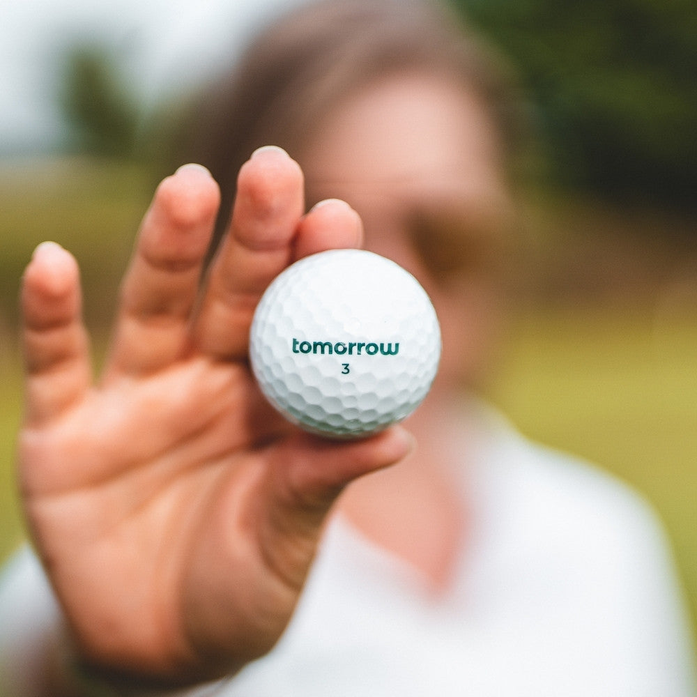 tomorrow golf ball close up holding in hand